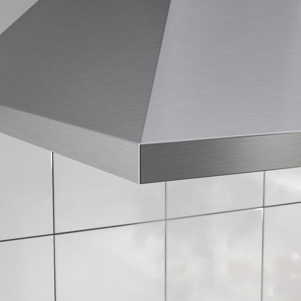 Stainless steel kitchen hood shown, sleek and modern design. Part of a clean, tiled kitchen.