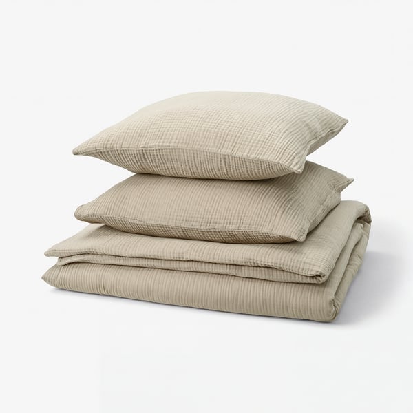 Stack of beige bed linens: duvet cover and pillows, textured, organic cotton.