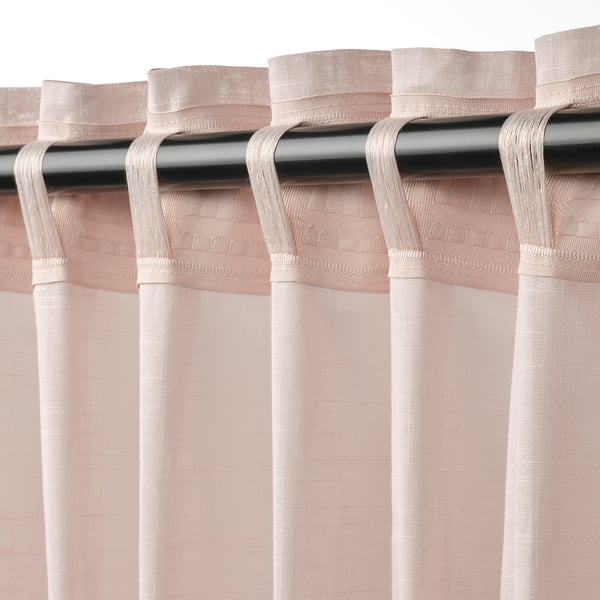 Pink sheer curtains with tab heading hang neatly from a silver rod, filtering light.