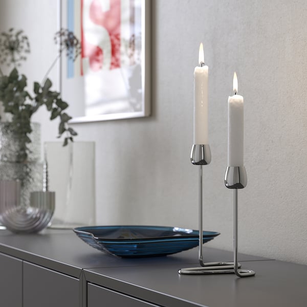 Silver candlestick holder SILVERPÄRON with two candles on dark surface.