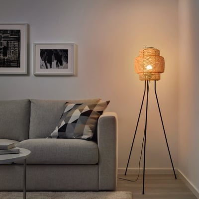 A cosy living room with SINNERLIG floor lamp, warm glow, and woven bamboo design.