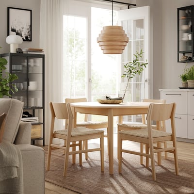 Modern dining room with SKANSNÄS wooden table and chairs, light wood, round shape, scandinavian design, hanging light, plants, shelves.
