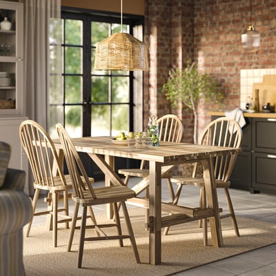 Brown wooden dining table with matching chairs and a woven pendant lamp.