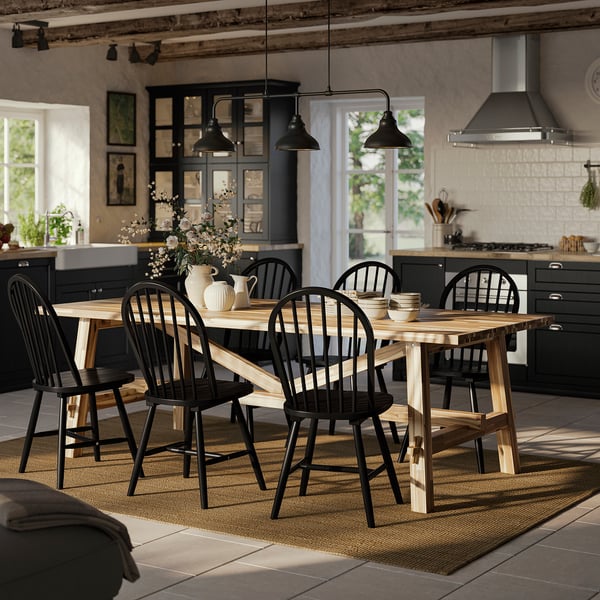 Modern farmhouse dining table & chairs. Wood top, metal base. Chairs tucked under. Rug in kitchen.