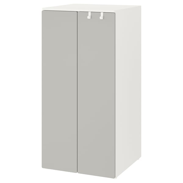 A white SMÅSTAD wardrobe, designed for children. Its square-shaped with two doors, soft-closing hinges, and adjustable feet for stability.