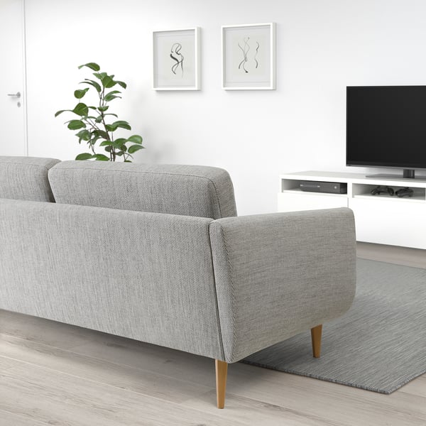 Modern living room with grey SMEDSTORP sofa, wooden legs, plant, tv, and art.