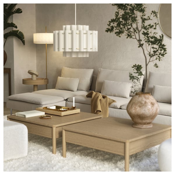Modern living room with SÖDERHAMN beige sofa, wooden coffee table, white chandelier, and green plants.