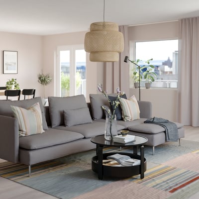 Modern living room: grey SÖDERHAMN sectional sofa, striped pillows, round coffee table, stylish pendant lamp, large window with city view.