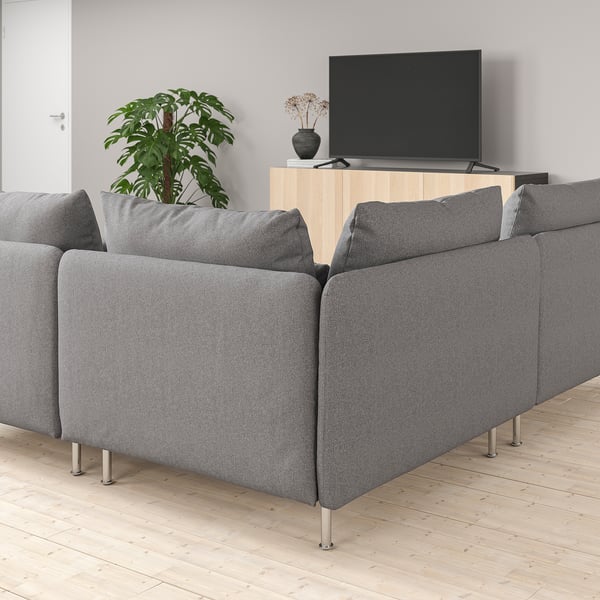 Modern living room with a SÖDERHAMN grey sofa, wooden tv stand, flat screen tv, and a tall indoor plant.