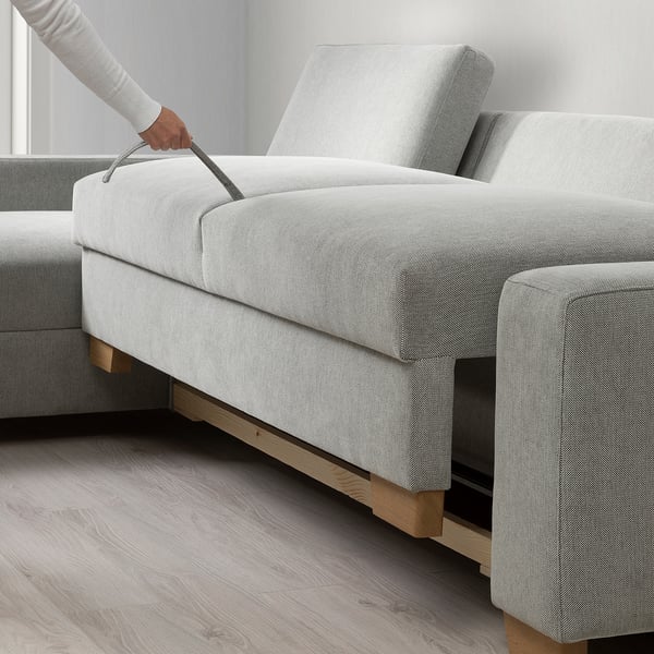 Hand lifting SÖRVALLEN sofas chaise with storage, showing its functional design.