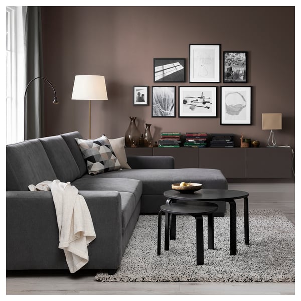 Modern living room with grey SÖRVALLEN sectional sofa, black nesting tables, patterned rug, and wall art.