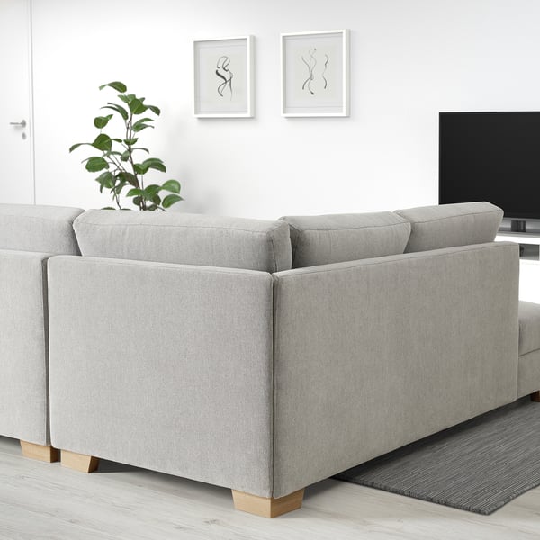 Light grey SÖRVALLEN sofa, modern minimalist design, large, with cushions, near plants and tv, in a minimalist room.