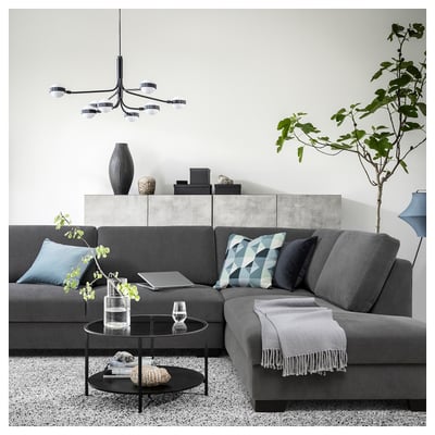 Modern living room with a grey SÖRVALLEN sectional sofa, geometric throw pillows, glass coffee table, and hanging light fixture.