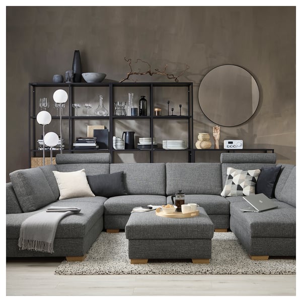Modern living room with grey SÖRVALLEN sectional sofa, cotton blend upholstery, surrounded by decorative shelves with items.