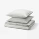 Stack of grey and white striped cotton bed linen, including duvet cover and pillows, neatly folded.