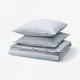 Stacked blue-and-white striped linens, including pillowcases and duvet cover, made of 100% cotton.