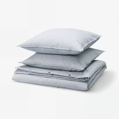 Stacked blue-and-white striped linens, including pillowcases and duvet cover, made of 100% cotton.
