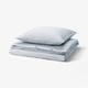 A stack of blue and white striped cotton duvet and pillow cases with a vintage charm.