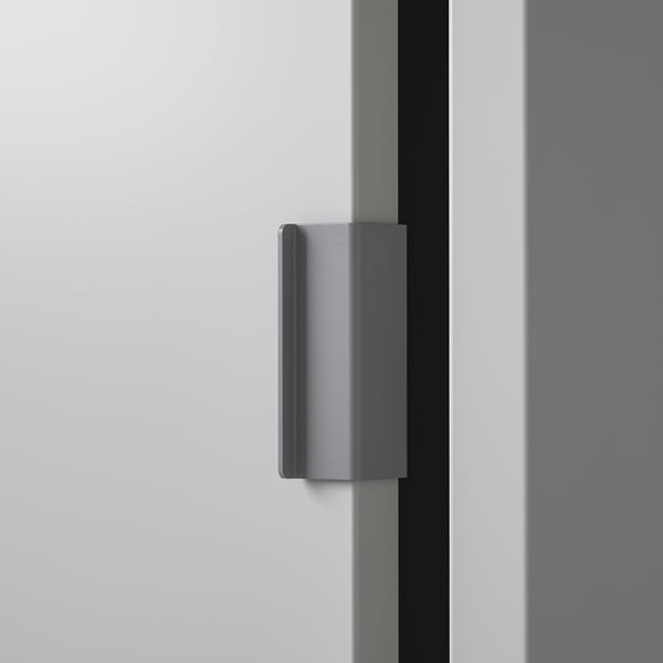 Modern, minimalist cabinet handle; sleek, metallic design; vertically mounted; high-quality finish.