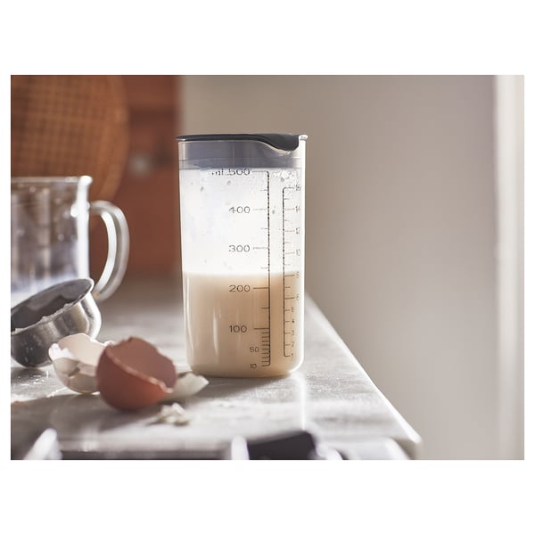 Plastic protein shaker. Graduated markings, leak-proof lid. Standing on countertop.