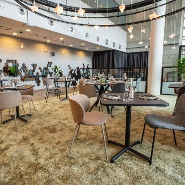 Modern café with STENSELE tables: square, black, laminate top, aluminium base, grouped in pairs, ideal for small spaces.