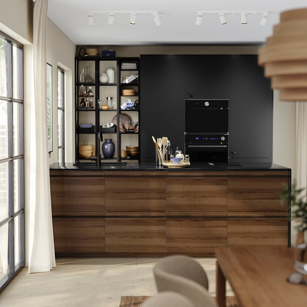 Elegant kitchen with dark brown wooden cabinets, black shelves, and integrated appliances.