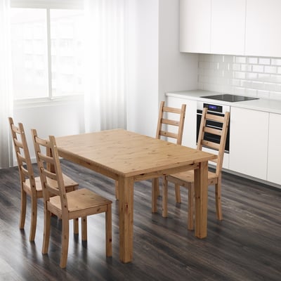 Wooden STORNÄS dining table with chairs, pine, seats 4-6, extendable, dark floor, white cabinets.