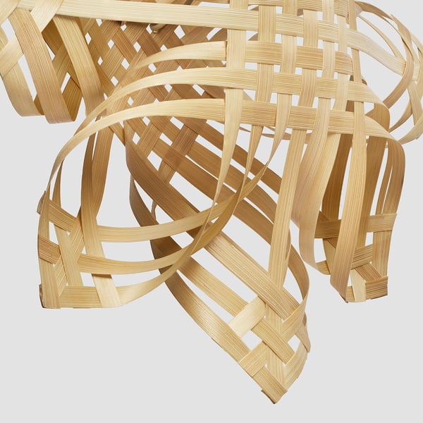 Woven bamboo lampshade, handcrafted with intricate design, emits warm, welcoming light, ideal for cosy rooms.