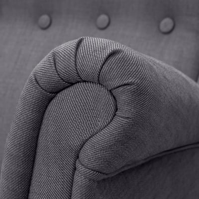 Close-up of high-quality, grey tweed fabric on a upholstered sofa armrest, showcasing its texture and detail.