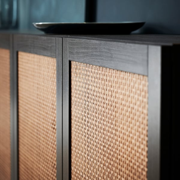Woven wooden cabinet doors, black framing, textured surfaces. Modern design with natural tones.