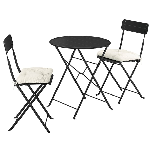 Black SUNDSÖ patio set with round table and 2 beige-cushioned folding chairs, ideal for small spaces.
