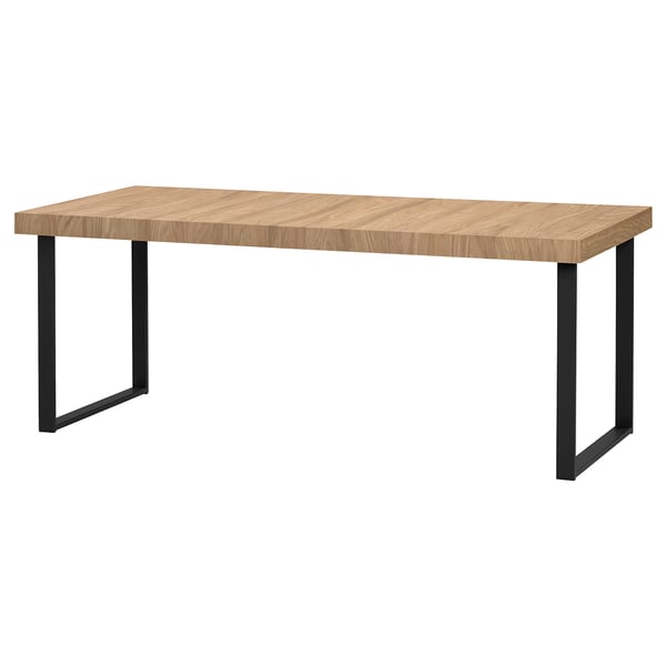 A TARSELE dining table with a light oak top and black metal legs, inspired by industrial design.