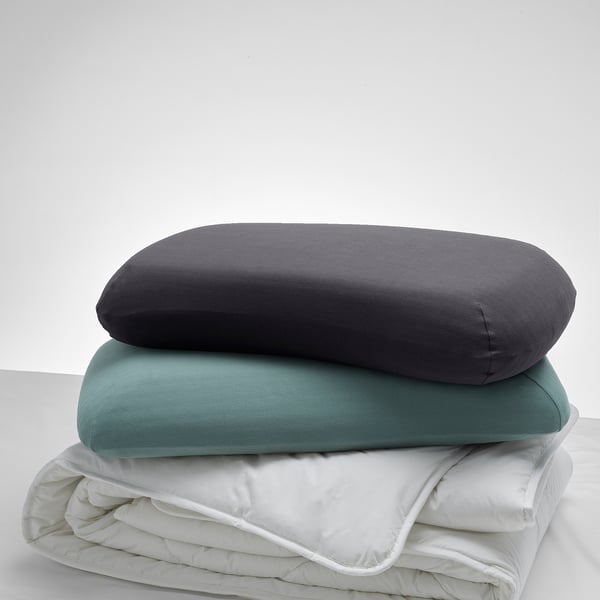 Three pillows stacked: top grey, middle teal, bottom white. Elastic edges, soft cotton blend. Grey pillow largest.