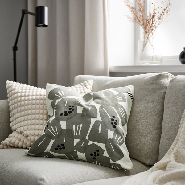 Cosy couch with UNDERBLOMMA pillow and decor.