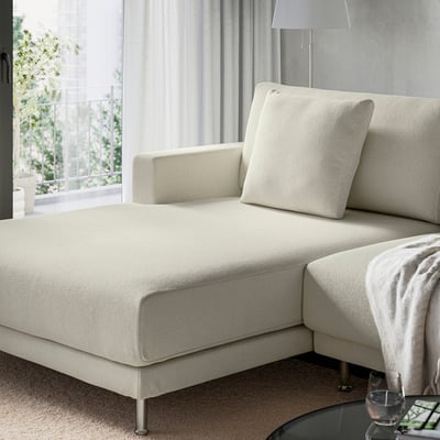 Cream sectional sofa with plush cushions near a window.