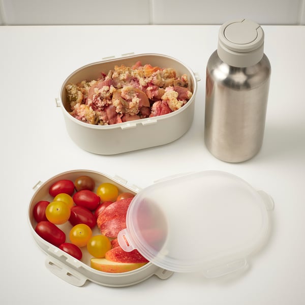 Two food containers, one with meat, the other with fruits. Beside them, a metal bottle. Perfect for packed meals.