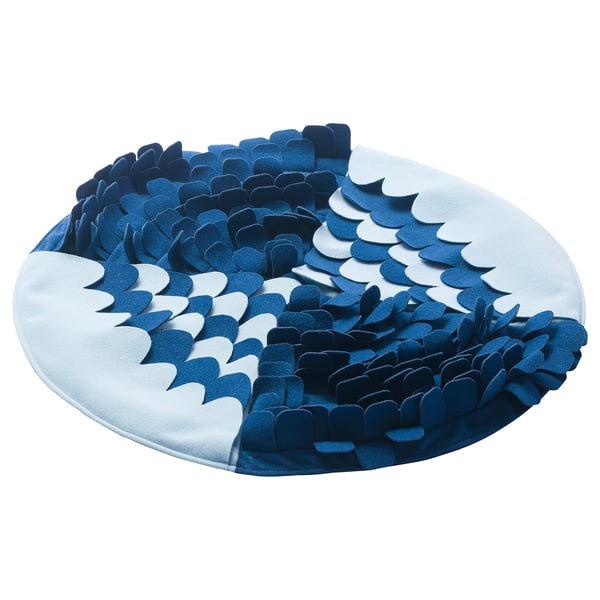 A blue, circular UTSÅDD snuffle mat for pets, featuring a ripple design with recycled polyester.