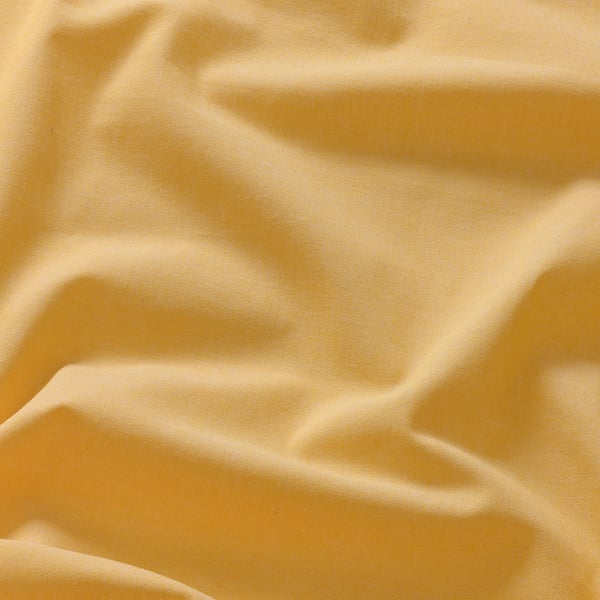 A close-up of a soft, golden yellow fabric with subtle texture, showcasing its smooth and slightly uneven surface, hinting at high-quality material.