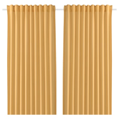 Two beige curtains hang side by side. They are solid, rectangular, and feature a rod pocket design, typically used for privacy and light control.