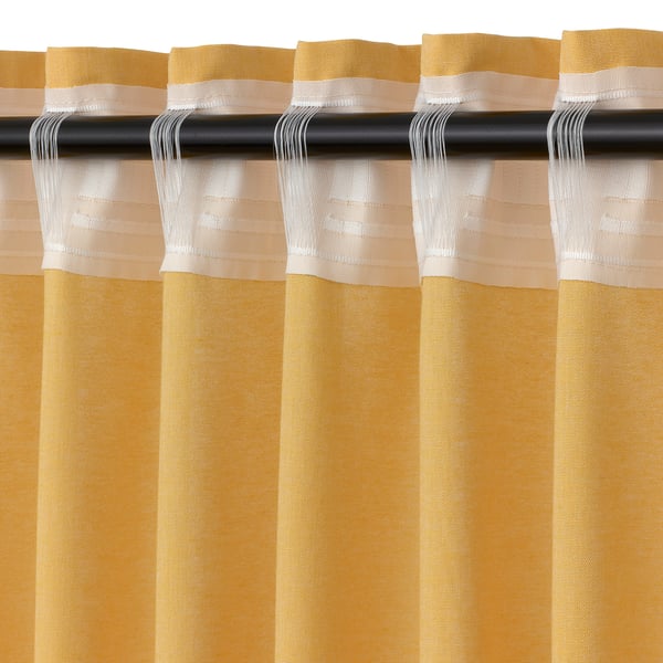 Yellow curtains with beige stripes hang neatly on a black rod, featuring pleated fabric and a professional finish.