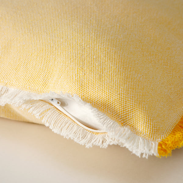 A bright yellow cushion cover with white fringes and a zip, showcasing a textured, woven fabric.