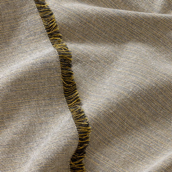Close-up of beige textured fabric with woven yellow and dark blue fringes, showcasing its texture and finish.