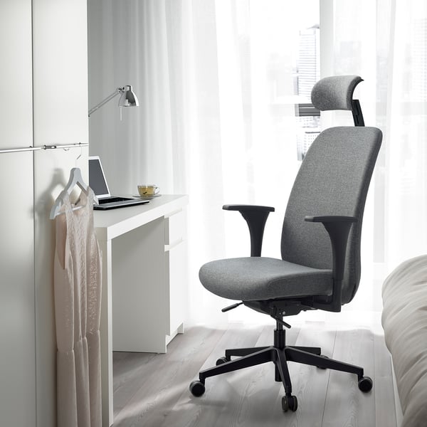 Ergonomic VALLFJÄLLET office chair by desk with laptop and cup.