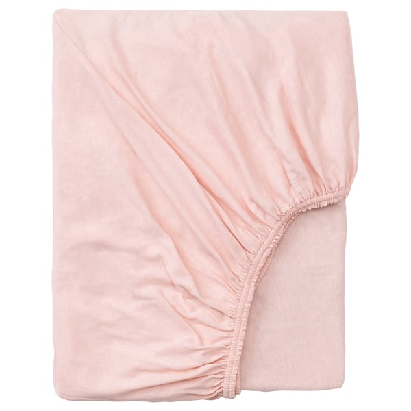 A peach-colored, soft cotton fitted bed sheet, neatly folded, with elastic edging for a secure fit.