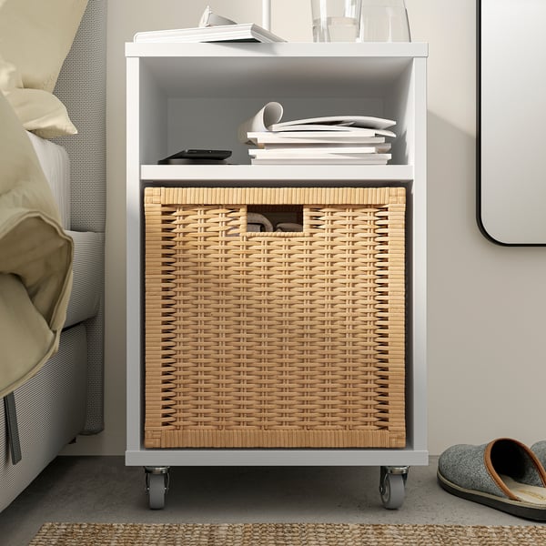 White VIHALS storage table with open shelf and woven basket, suitable for small items and devices.