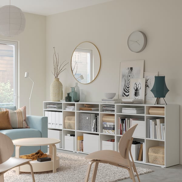 Modern living room with white VIHALS storage shelves, light blue sofa, wooden chair, and decorative items.