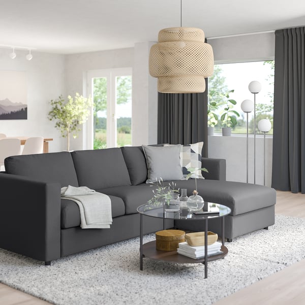 Modern living room with grey VIMLE sofa, cushions, coffee table, and unique lamp.