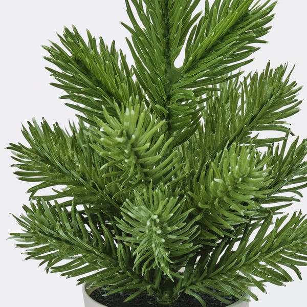 Close-up of realistic artificial pine tree branch, showcasing vibrant green, needle-like leaves densely packed together.