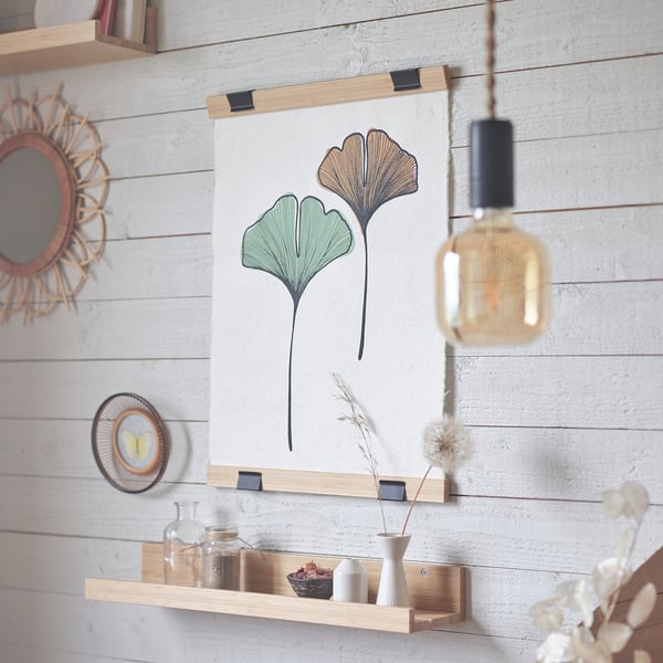 Minimalist bedroom with VISBÄCK poster hanger, light bulb, and vases.
