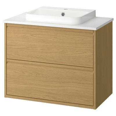 Et lysebrunt trævaskerum med skuffer og en hvid marmorbordplade, der bar en rektangulær hvid vask. Moderne design med minimalistiske detaljer.